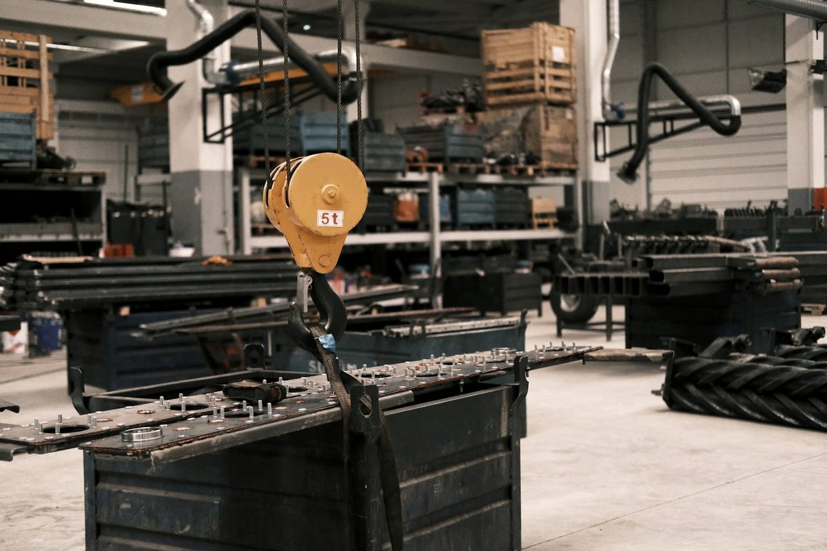 A rated 5-ton lifting block and hook rigged to steel in an industrial shop
